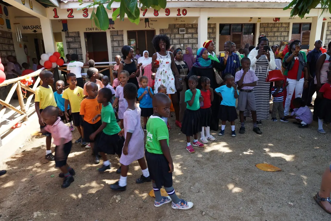 Viele Kinder und Erwachsene versammeln sich im Hof der Schule in Ukunda, Kenia