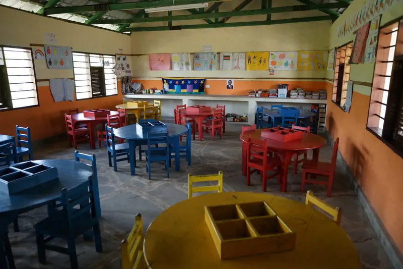 Klassenraum mit bunten Kindertischen und -stühlen