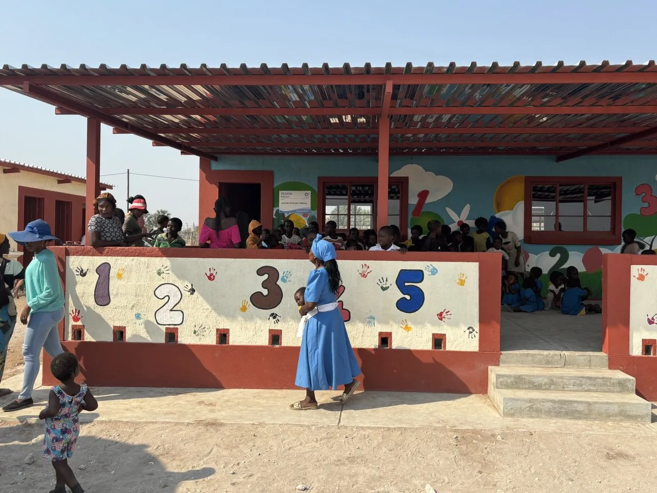 Schulgebäude in Ruuga, Namibia, mit großen Zahlen an der Wand und Kindern davor