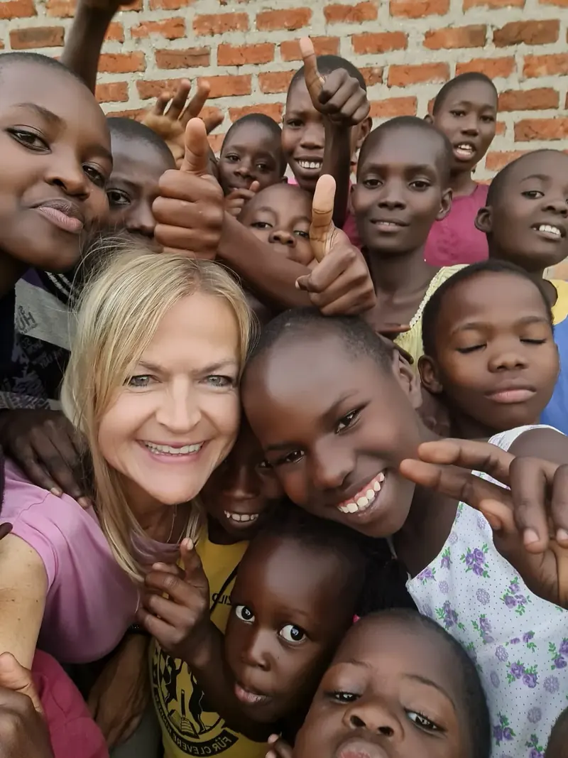 Eine Frau macht ein Selfie mit einer Gruppe lachender Kinder